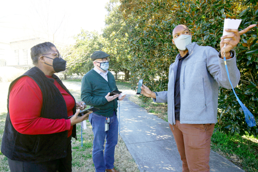 People walk in their community and conduct air quality testing with mobile applications.