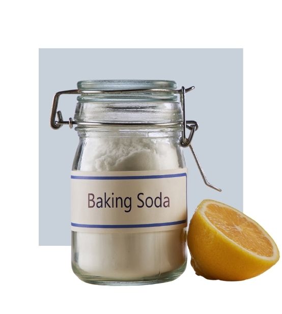 An image of a container of baking soda and half a lemon