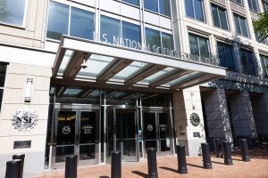 Entrance to office building with large windows and awning over entrance. Sign above entrance reads U.S. National Science Foundation.
