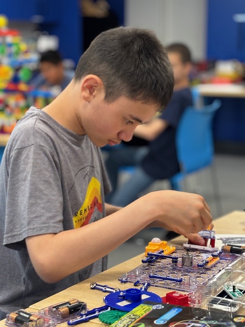 A tween boy builds with Snap Circuits.